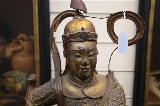 A large Chinese gilt-decorated and polychrome lacquer figure of a temple guardian, 19th century, H.75cm, losses